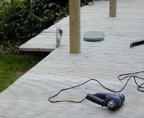 Overhang of fixed decking boards being trimmed